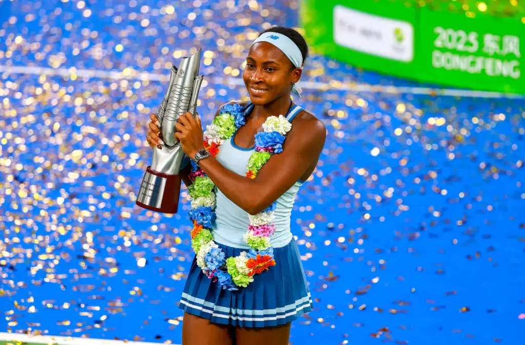 US tennis star Coco Gauff smiles while holding her 2025 Wuhan Open championship trophy.