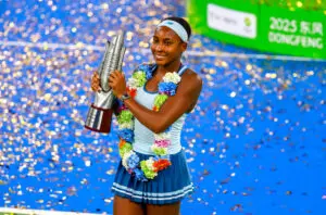 US tennis star Coco Gauff smiles while holding her 2025 Wuhan Open championship trophy.