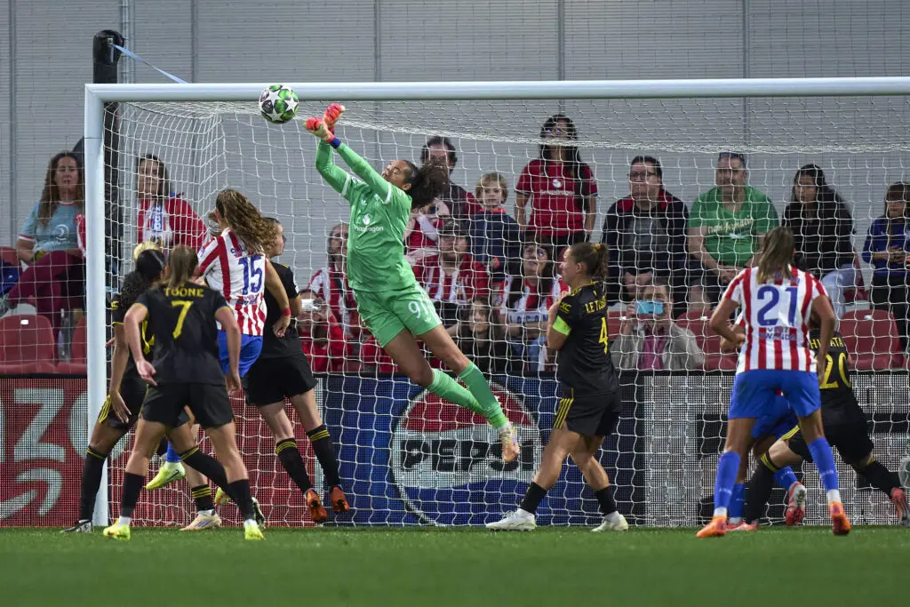 Manchester United goalkeeper Phallon Tullis-Joyce punches away the ball to make a dramatic save in a 2025/26 Champions League match.