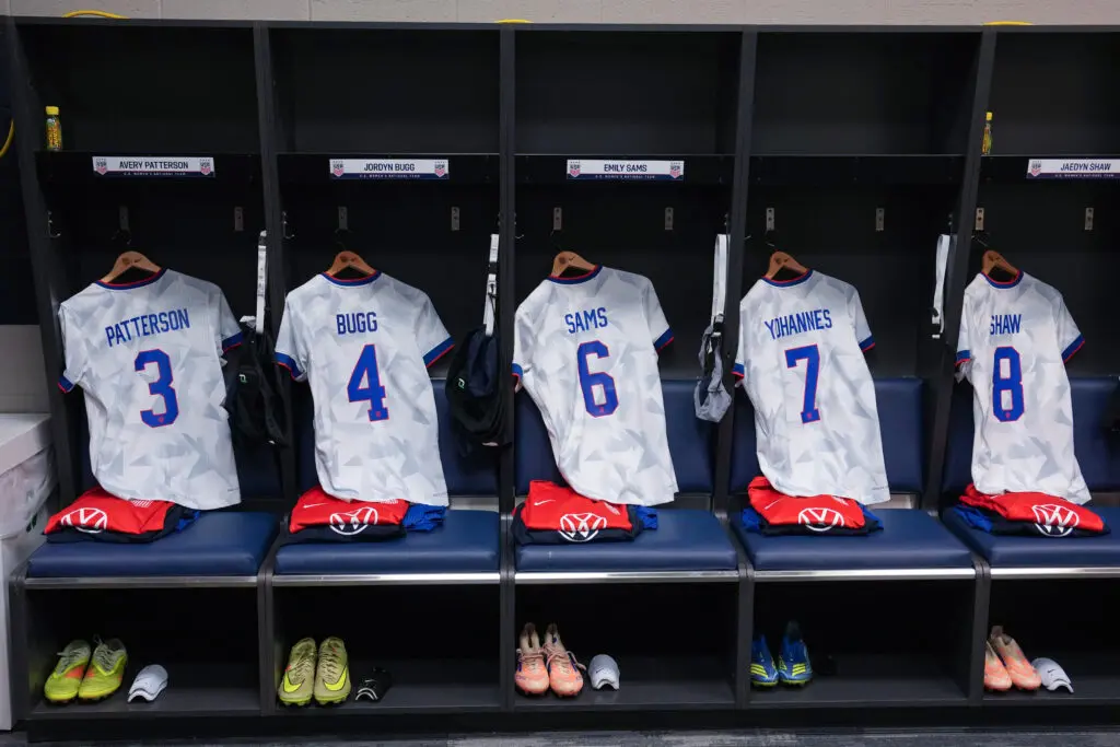 USWNT jerseys for Avery Patterson, Jordyn Bugg, Emily Sams, Lily Yohannes, and Jaedyn Shaw hang in a locker room before a 2025 friendly.