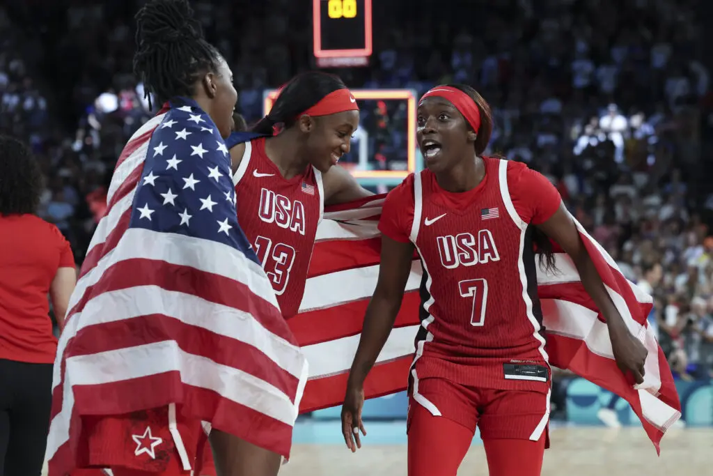 Team USA stars Chelsea Gray, Jackie Young, and Kahleah Copper celebrate their gold-medal win at the 2024 Paris Olympics.