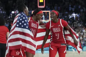 Team USA stars Chelsea Gray, Jackie Young, and Kahleah Copper celebrate their gold-medal win at the 2024 Paris Olympics.