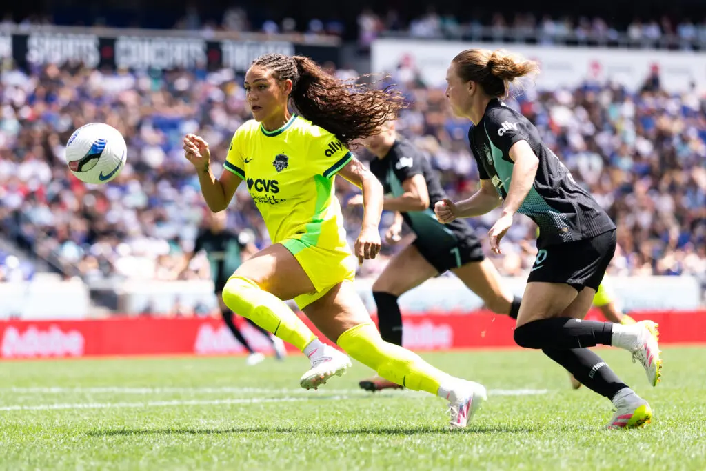 Washington Spirit forward Trinity Rodman and Gotham FC defender Emily Sonnett chase the ball during a 2025 NWSL match.