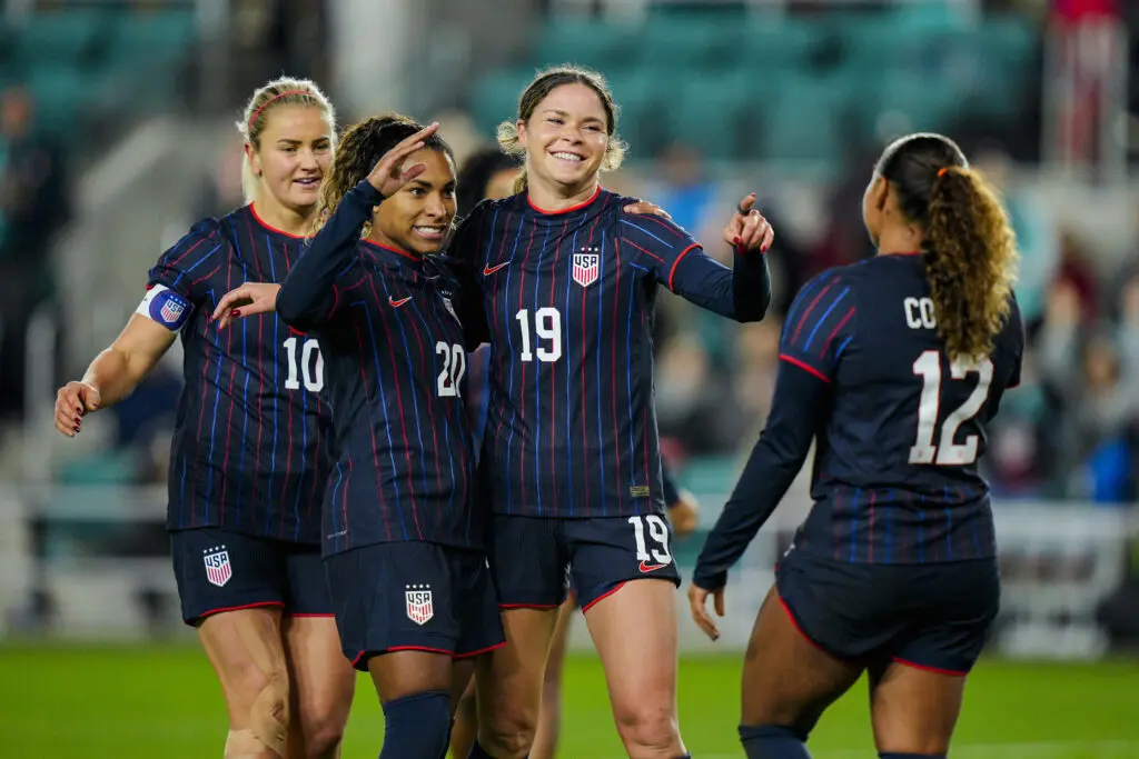 USWNT forward Emma Sears celebrates a goal with teammates Lindsey Heaps, Catarina Macario, and Michelle Cooper during an October 2025 friendly.