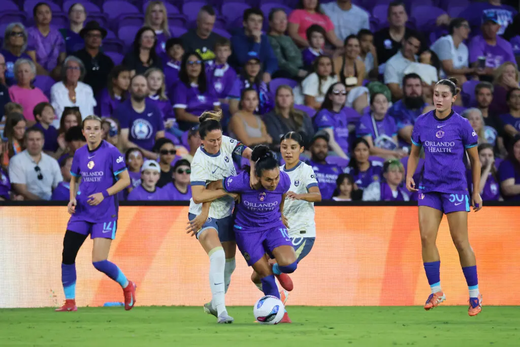 Seattle Reign defender Lauren Barnes battles Orlando Pride attacker Marta for the ball during a 2025 NWSL match.
