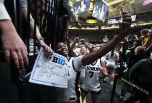 Iowa guard Journey Houston takes a selfie with fans after a 2025/26 NCAA basketball game.