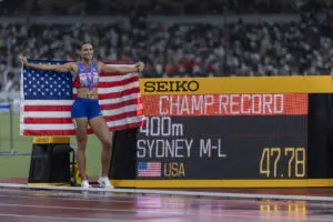 US track star Sydney McLaughlin-Levrone poses next to her 400-meter final championship-record time at the 2025 World Athletics Championships.
