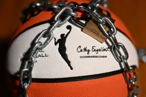 An official WNBA basketball sits with a lock and chain around it to warn of a potential league lockout without a new CBA.