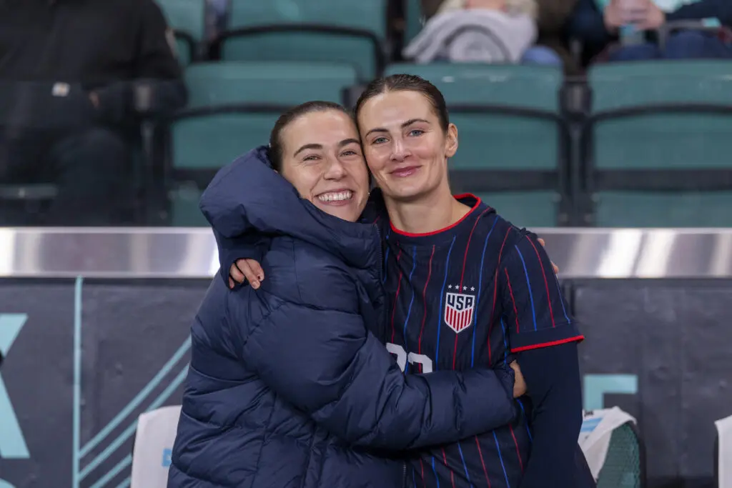 USWNT midfielder Sam Coffey hugs defender Emily Fox at a 2025 friendly.