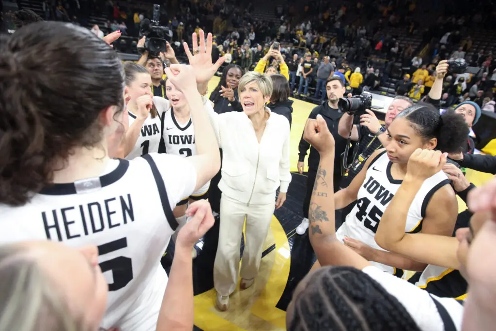 Iowa head coach Jan Jensen talks to her players in a huddle after a 2025/26 NCAA basketball win.