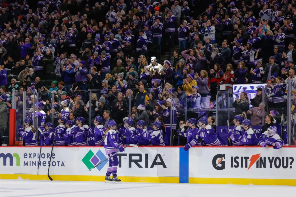 The Minnesota Frost bench congratulates forward Dominique Petrie on her goal during a 2025 PWHL game.