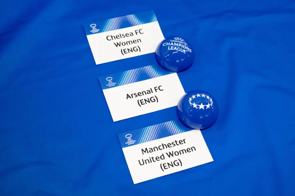 The 2025/26 Champions League draw cards for WSL clubs Chelsea, Arsenal, and Manchester United sit on a table before the draw for the playoffs and quarterfinals rounds.