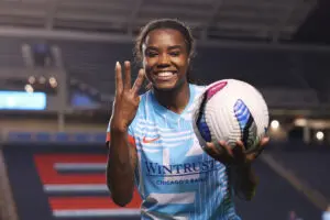 Chicago Stars striker Ludmila smiles while putting up three fingers and holding the game ball after scoring a hat trick in a 2025 NWSL match.