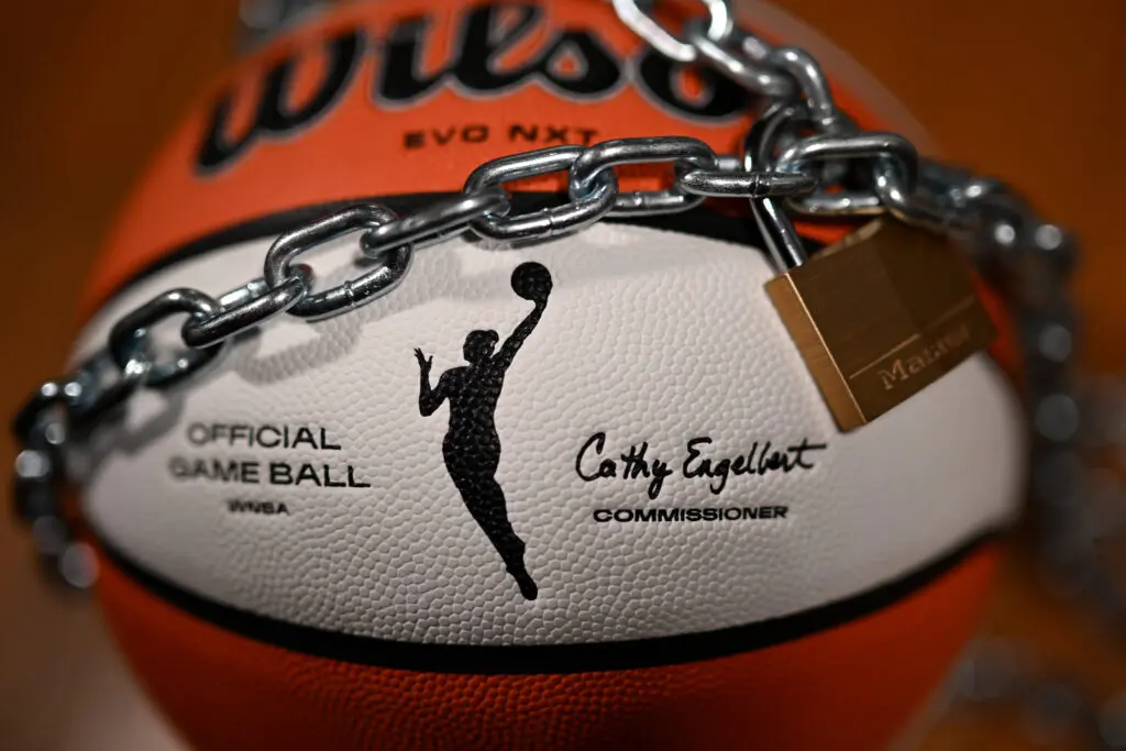 A WNBA basketball with a lock and chain around it.