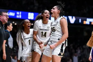 Vanderbilt teammates Sacha Washington, Aiyana Mitchell, and Mikayla Blakes celebrate a play during a 2025/26 NCAA basketball game.