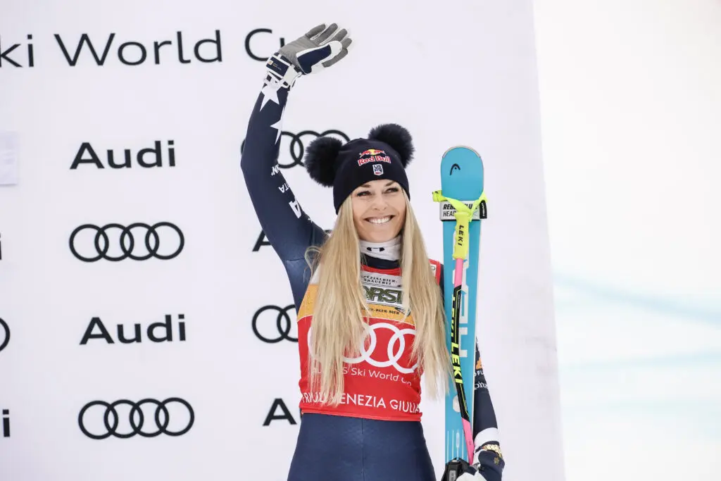 US ski star Lindsey Vonn smiles and waves from the podium at a 2026 FIS World Cup competition.