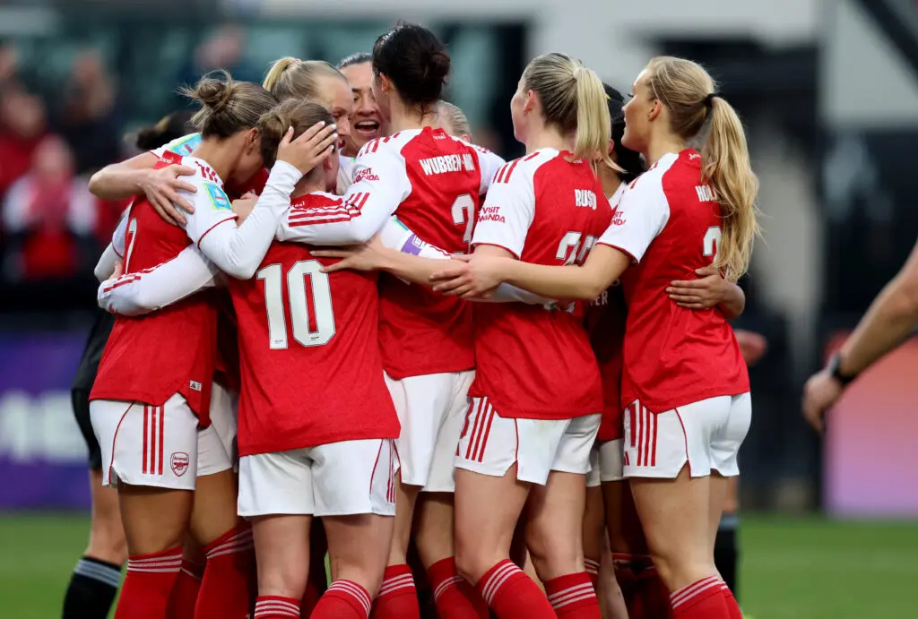 Arsenal teammates hug in celebration of a goal during a 2025/26 FA Cup match.