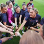 USWNT captain Trinity Rodman addresses her teammates in a huddle before a 2026 friendly against Paraguay.