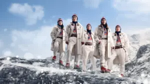 A graphic of models in the Team USA opening ceremony outfit for the 2026 Winter Olympics standing on an icy mountaintop.