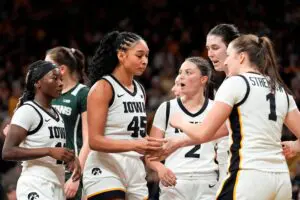 Iowa guard Chit-Chat Wright, forward Hannah Stuelke, guard Taylor McCabe, center Ava Heiden, and guard Taylor Stremlow huddle during a 2025/26 NCAA basketball game.