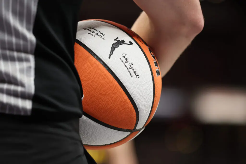 A referee holds an official WNBA basketball during a 2024 game.