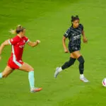 Kansas City Current midfielder Claire Hutton chases Washington Spirit star Croix Bethune, who controls the ball, during a 2025 NWSL match.