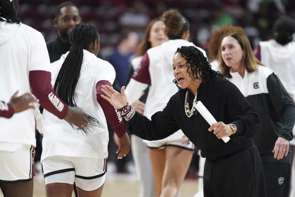 South Carolina head coach Dawn Staley high-fives her players before a 2024/25 NCAA basketball game.
