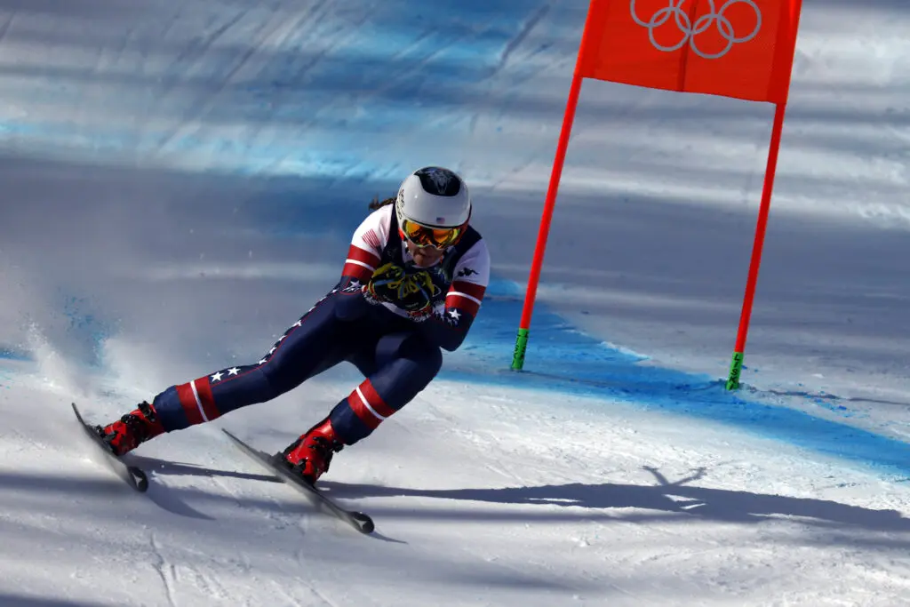 USA ski star Breezy Johnson passes a flag during the 2026 Olympic downhill race.