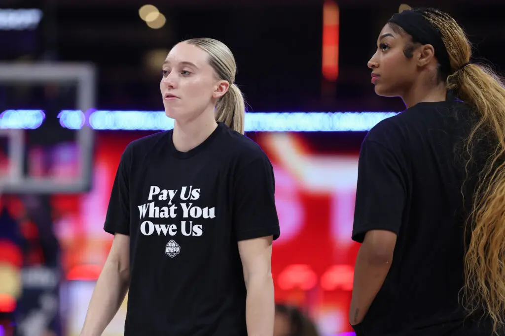 Paige Bueckers and Angel Reese wear T-shirts saying "Pay Us What You Owe Us" ahead of the 2025 WNBA All-Star Game.