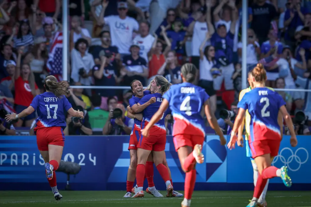 USWNT players run to celebrate a goal by forward Mallory Swanson during the gold-medal match at the 2024 Paris Olympics.