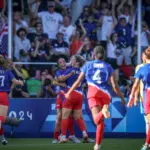 USWNT players run to celebrate a goal by forward Mallory Swanson during the gold-medal match at the 2024 Paris Olympics.