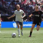 Seattle Reign star Jess Fishlock dribbles the ball as Portland Thorns midfielder Olivia Moultrie challenges during a 2025 NWSL match.