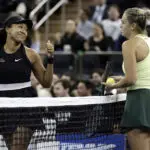 Naomi Osaka gives Aryna Sabalenka a thumbs up at the net during a 2025 tennis exhibition.