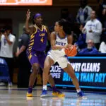 LSU guard Flau'jae Johnson defends as Duke guard Ashlon Jackson looks to pass the basketball during a 2025/26 NCAA game.