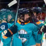 New York Sirens teammates celebrate a goal during a 2025/26 PWHL game.
