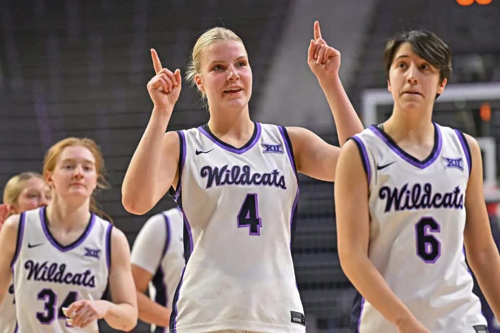 Kansas State forward Nastja Claessens points up in celebration as she walks off the court with teammates Tess Heal and Gina Garcia after their first-round 2026 Big 12 basketball tournament win.