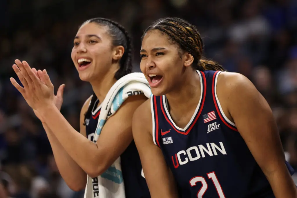 UConn stars Azzi Fudd and Sarah Strong celebrate during a 2025/26 NCAA women's basketball game.