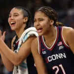UConn stars Azzi Fudd and Sarah Strong celebrate during a 2025/26 NCAA women's basketball game.