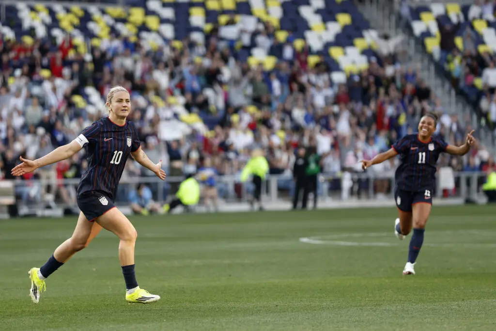 USWNT captain Lindsey Heaps and defender Kennedy Wesley run across the pitch to celebrate Heaps's goal during a 2026 SheBelieves Cup match.