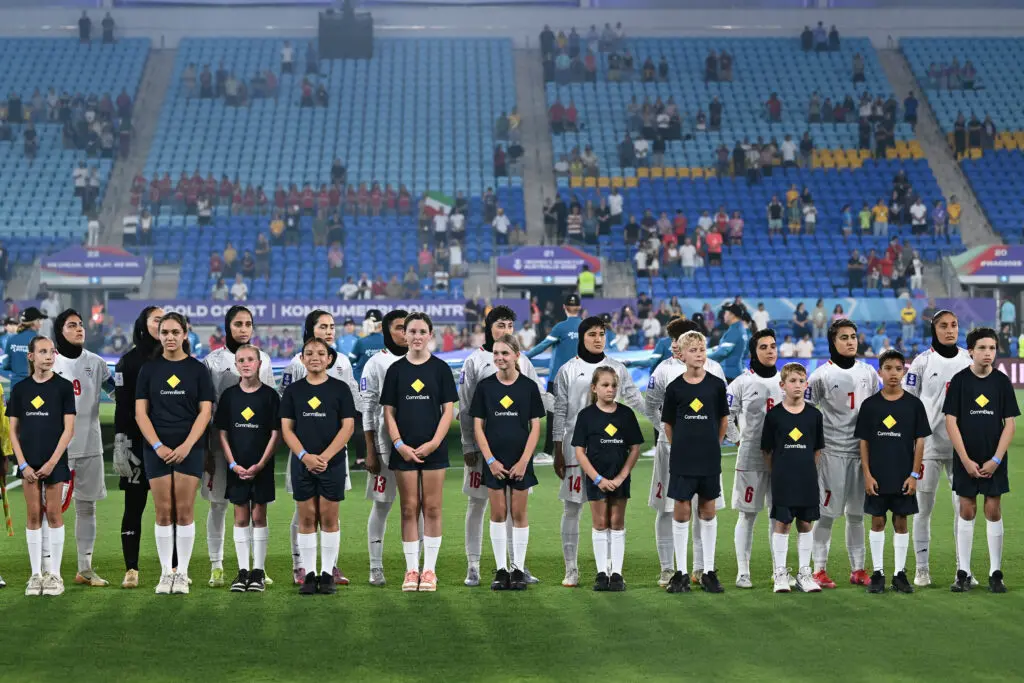 Iran women's national team players line up for anthems before a 2026 AFC Asian Cup match.