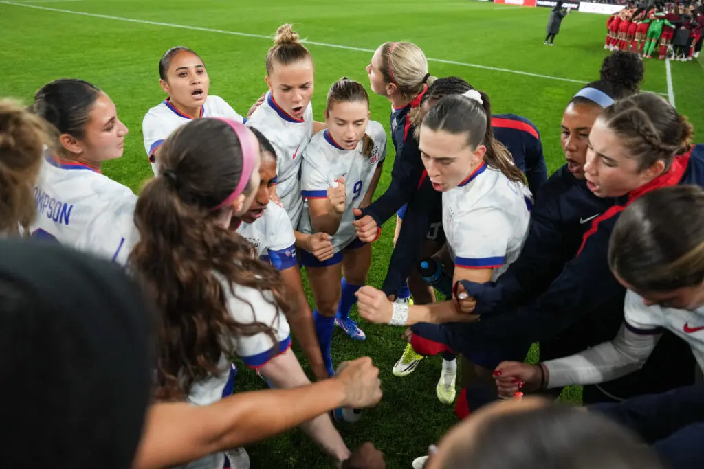 USWNT players huddle before a 2026 SheBelieves Cup match.
