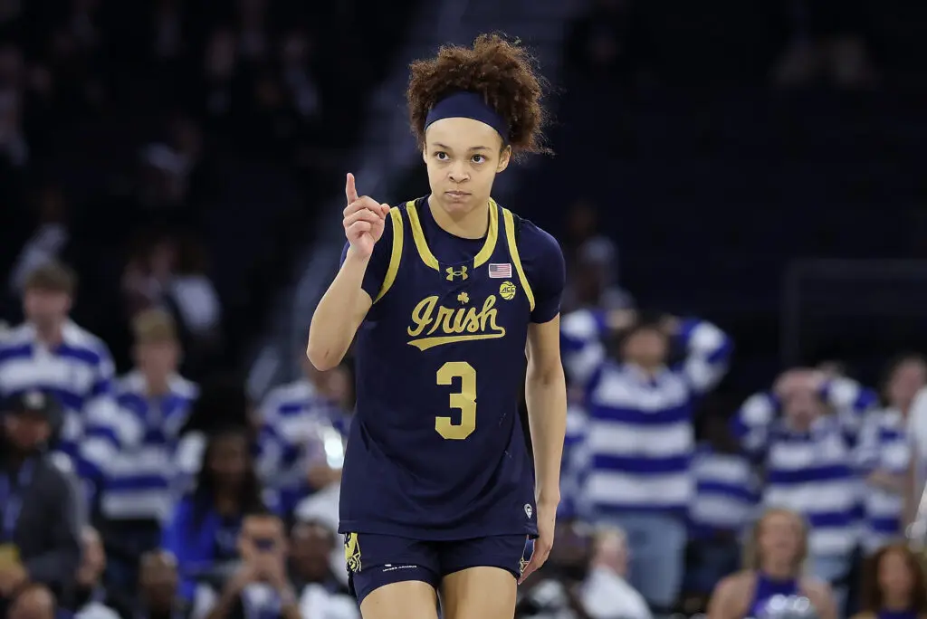 Notre Dame guard Hannah Hidalgo points intensely after sinking a three during a 2026 ACC women's basketball tournament game.