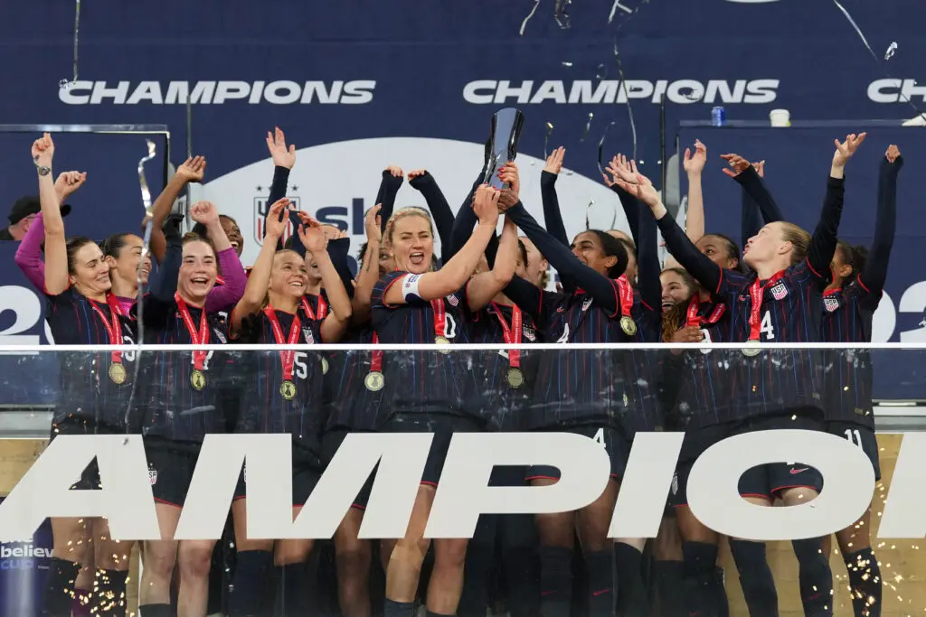 The USWNT cheers as captains Lindsey Heaps and Naomi Girma lift the 2026 SheBelieves Cup.