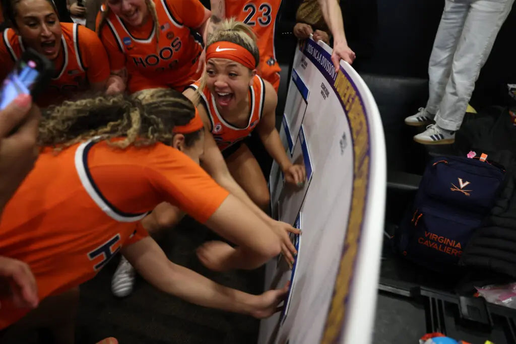 Virginia teammates celebrate their second-round upset win over Iowa while advancing their placard to the Sweet Sixteen on the 2026 March Madness bracket.