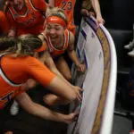 Virginia teammates celebrate their second-round upset win over Iowa while advancing their placard to the Sweet Sixteen on the 2026 March Madness bracket.