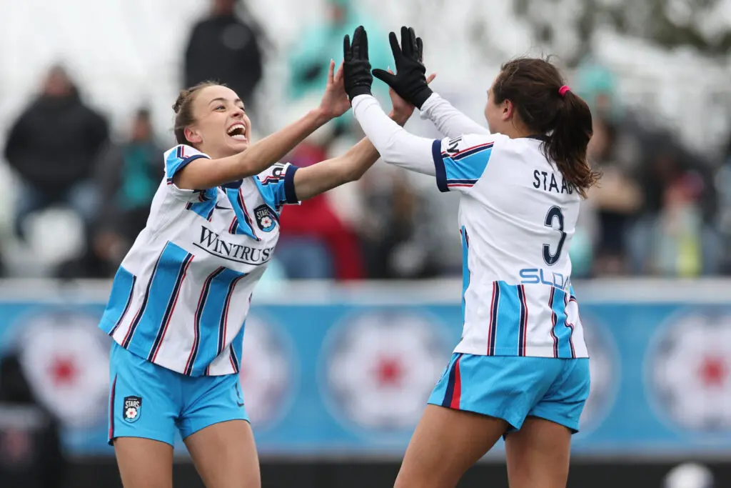 Chicago Stars midfielder Julia Grosso and center back Sam Staab high-five after a goal from teammate Tessa Dellarose during a 2026 NWSL match.