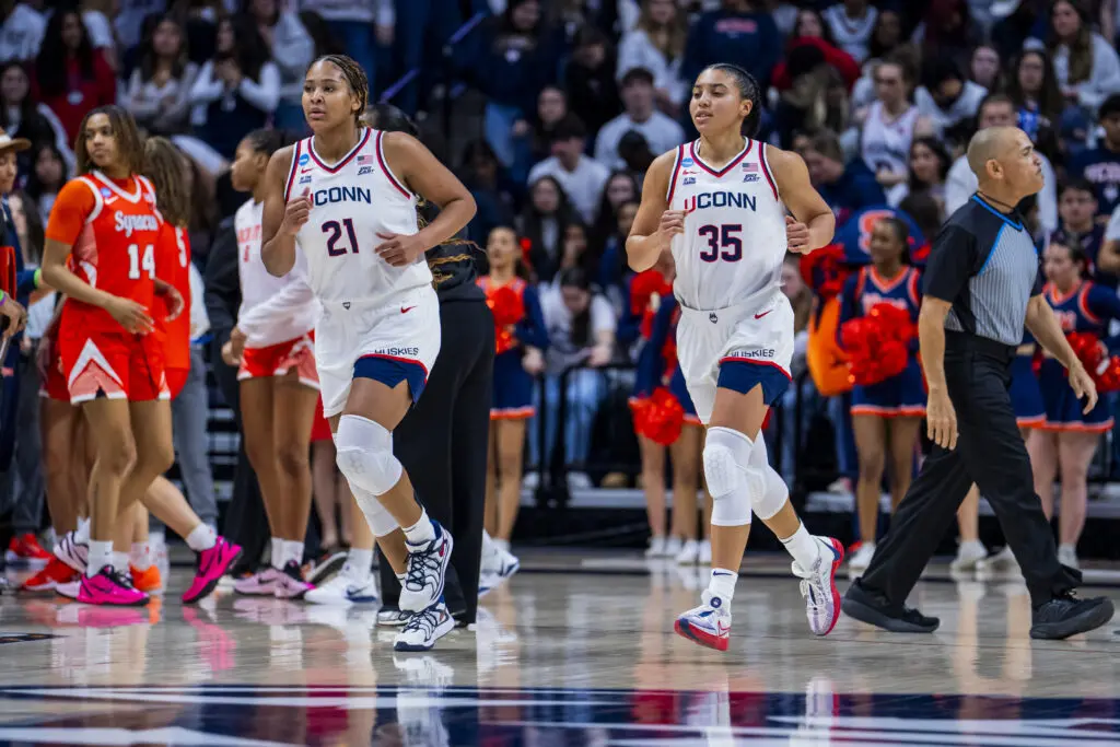 UConn stars Sarah Strong and Azzi Fudd jog across the court during their second-round game in the 2025/26 NCAA women's basketball tournament.
