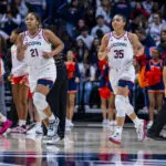 UConn stars Sarah Strong and Azzi Fudd jog across the court during their second-round game in the 2025/26 NCAA women's basketball tournament.