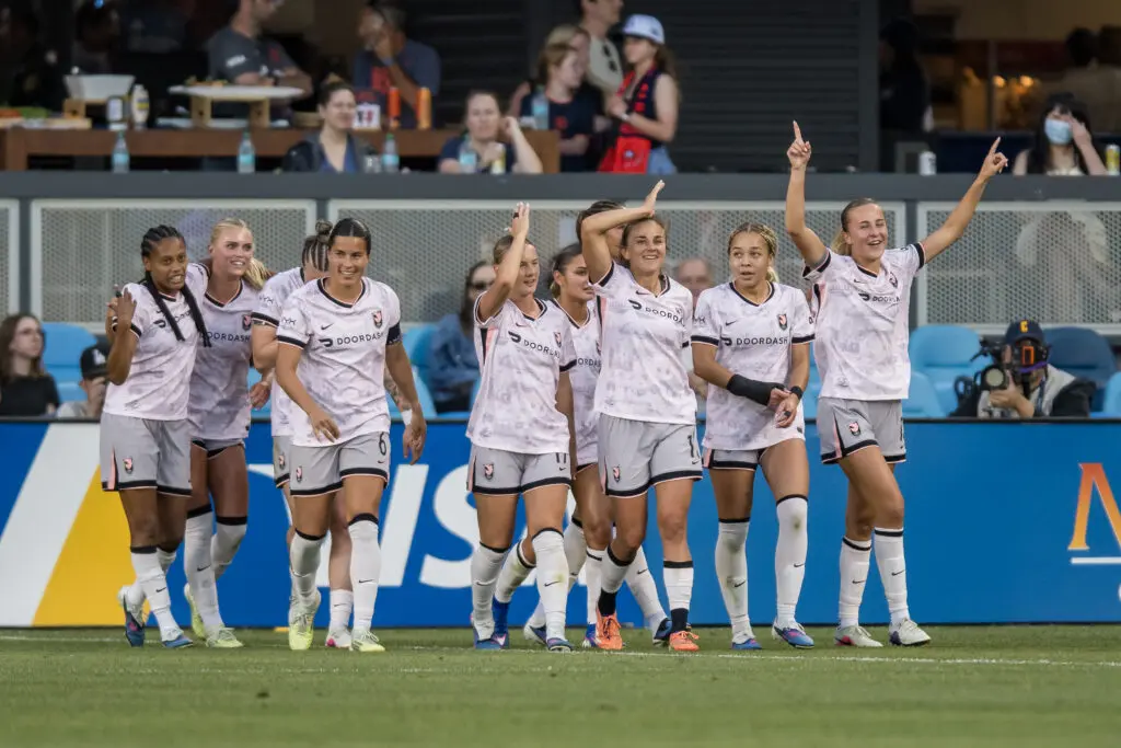 Angel City teammates celebrate a goal during a 2026 NWSL match.
