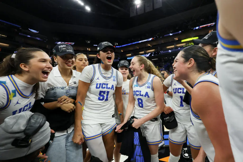 UCLA players celebrate their 2026 Elite Eight win in a huddle.